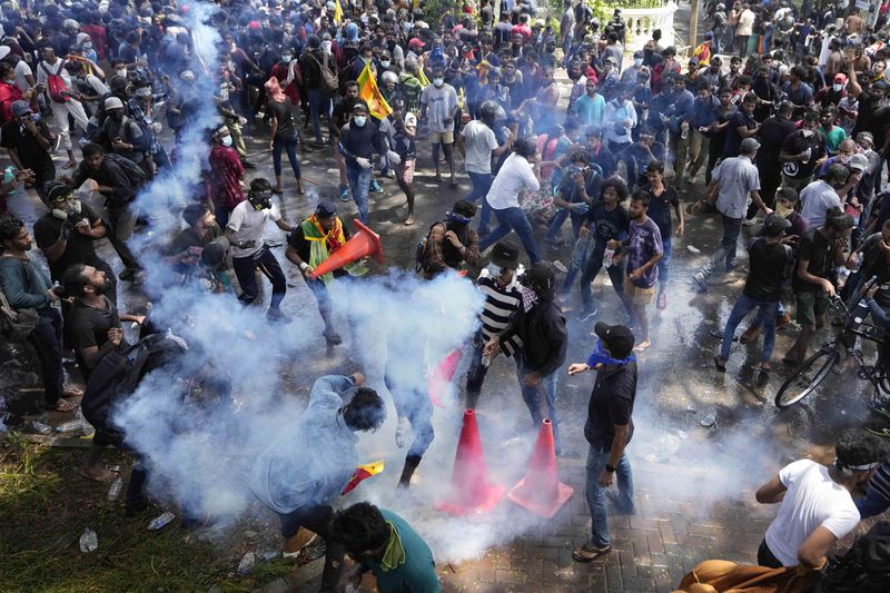 A tear gas canister lands amidst the protesters storming the compound of Sri Lankan Prime Minister Ranil Wickremesinghe's office demanding he resign after president Gotabaya Rajapaksa fled the country amid economic crisis, in Colombo, Sri Lanka, Wednesday, July 13, 2022. (AP Photo/Eranga Jayawardena, File)