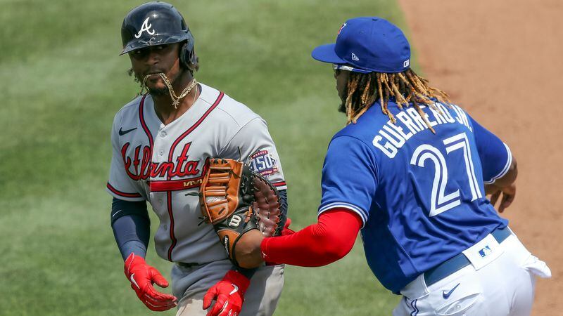 Braves second baseman Ozzie Albies (left) is tagged out by Toronto Blue Jays' Vladimir Guerrero Jr. after being caught in a rundown between first and second base during the sixth inning Sunday, May 2, 2021, in Dunedin, Fla. (Mike Carlson/AP)