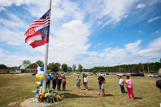 Community members gathered by the flag pole to pay respect to the victims at Apalachee High School in Winder, Georgia, on Thursday, September 5, 2024. A day after, a 14-year-old opened fire at a Barrow County high school on Wednesday morning, killing two students and two teachers and injuring nine others. (Miguel Marttinez/AJC)