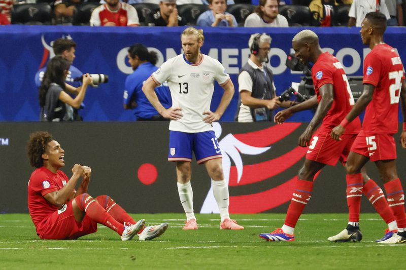 Panama players celebrate as U.S. defender Tim Ream (13) watches after Panama's win during a Copa América 2024 Group C soccer match Thursday, June 27, 2024, in Atlanta. (Miguel Martinez//Atlanta Journal-Constitution via AP)