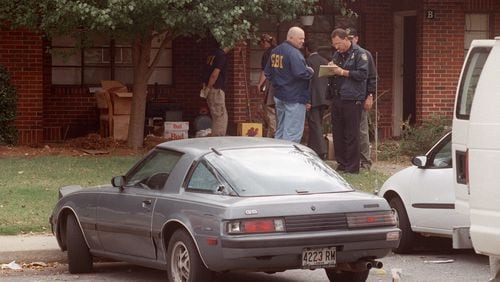 OCTOBER 1997: Officials from the GBI and the Atlanta Police Department investigate the scene where Officer John “Rick” Sowa was murdered, and his partner Officer Pat Cocciolone was wounded, on Oct. 12, 1997. (Kimberly Smith/ AJC file photo)