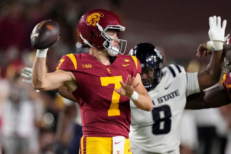 Southern California quarterback Miller Moss, left, passes as Utah State defensive tackle Taz Williams runs in during the first half of an NCAA college football game, Saturday, Sept. 7, 2024, in Los Angeles. (AP Photo/Mark J. Terrill)