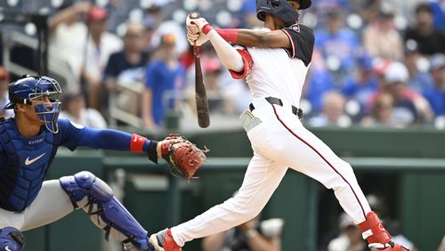 Chicago Cubs catcher Miguel Amaya, left, watches Washington Nationals' Darren Baker get his first major league hit during the ninth inning of a baseball game, Sunday, Sept. 1, 2024, in Washington. (AP Photo/John McDonnell)