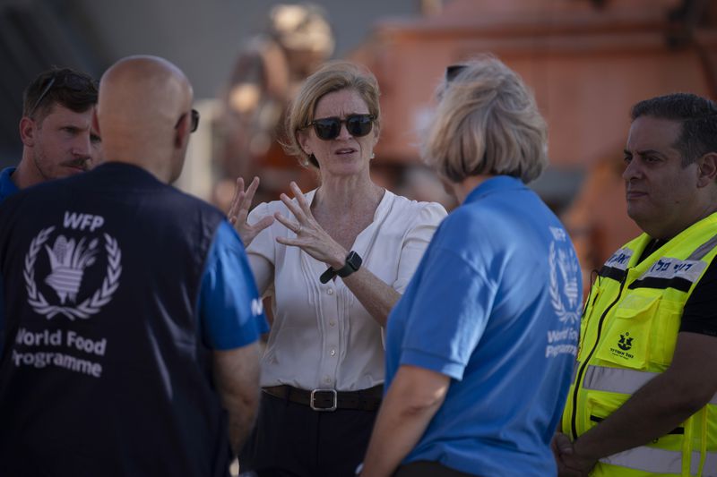 U.S. Agency for International Development Administrator Samantha Power, center, talks to World Food Program (WFP) members as they visit the port where cargo ships arrive, carrying humanitarian aid for Gaza Strip, in Ashdod, Israel, Thursday, July 11, 2024. (AP Photo/Leo Correa)
