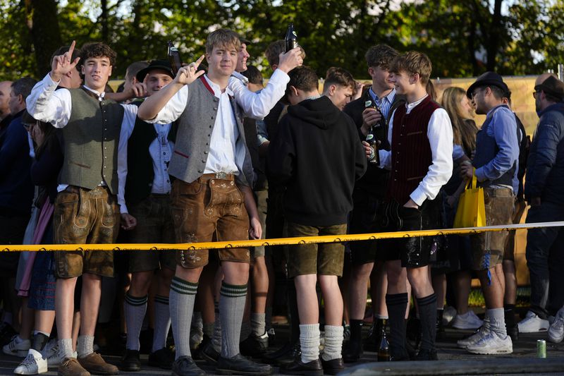 Young visitors await the start of the 189th 'Oktoberfest' beer festival in Munich, Germany, Saturday, Sept. 21, 2024. (AP Photo/Matthias Schrader)