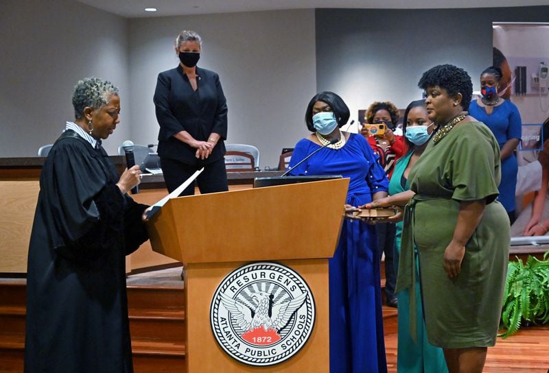 Fulton County State Court Judge Patsy Porter swears in Atlanta Public Schools Superintendent Lisa Herring (right) as Lena Jordan Herring, mother of Lisa Herring, and Imani Herring, daughter of Lisa Herring, watch on Tuesday, June 30, 2020. (Hyosub Shin / Hyosub.Shin@ajc.com)