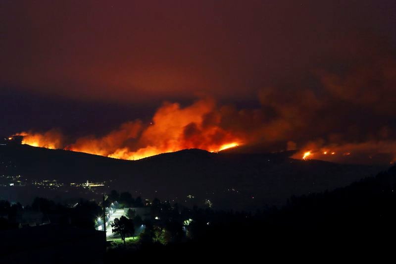 Fires rage on the hills around Sever do Vouga, a town in northern Portugal that has been surrounded by forest fires, Tuesday night, Sept. 17, 2024. (AP Photo/Bruno Fonseca)