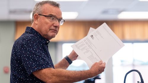 Cobb County resident Eugene Williams holds papers related to his challenge against the registrations of 2,472 voters during a Cobb County Board of Elections and Registration meeting Saturday at the Cobb County Safety Village in Marietta.
