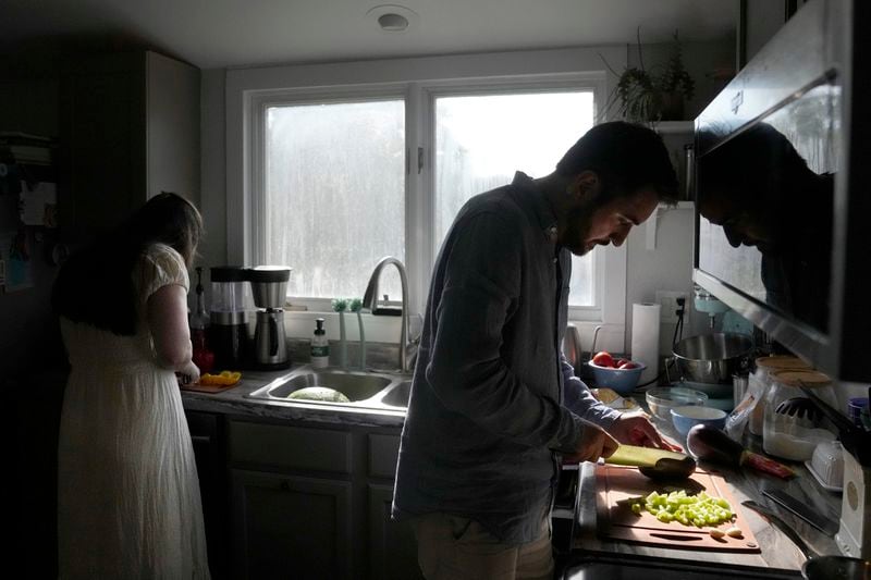 Julia Manetta, left, and her husband, Steven Manetta, a cancer patient, work on dinner Thursday, Aug. 29, 2024, in their Lemont, Ill., home. (AP Photo/Charles Rex Arbogast)