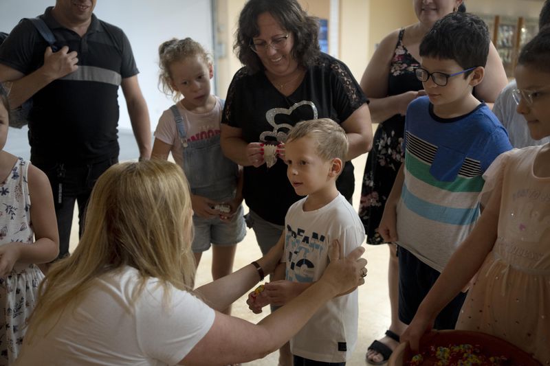 Ariel Heller, 4, center, is welcomed by Dr. Inbal Rivlin for a special tour after the child accidentally broke an ancient jar at the Reuben and Edith Hecht Museum in Haifa, Israel, Friday, Aug. 30, 2024. The boy who accidentally broke a rare 3,500-year-old jar in an Israeli museum has been forgiven and invited back, as curators hope to turn the disaster into a teachable moment. (AP Photo/Maya Alleruzzo)