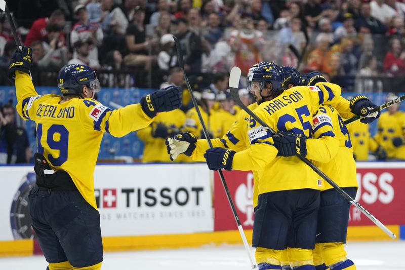 Sweden's Erik Karlsson celebrates with teammates after scoring his sides second goal during the bronze medal match between Sweden and Canada at the Ice Hockey World Championships in Prague, Czech Republic, Sunday, May 26, 2024. (AP Photo/Petr David Josek)