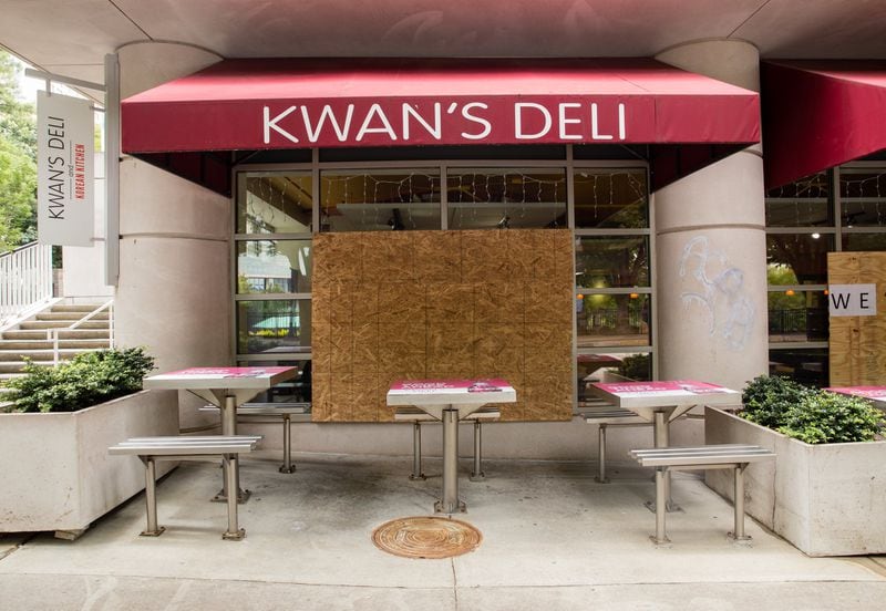 Kwan’s Deli at Centennial Olympic Park sustained damages from rioters and has several broken, boarded-up windows but is still open for business Wednesday, June 17, 2020. (Jenni Girtman for The Atlanta Journal-Constitution)