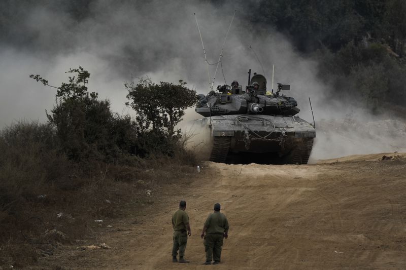 Israeli army tanks manoeuvre in a staging area in northern Israel near the Israel-Lebanon border, Tuesday, Oct. 1, 2024. (AP Photo/Baz Ratner)