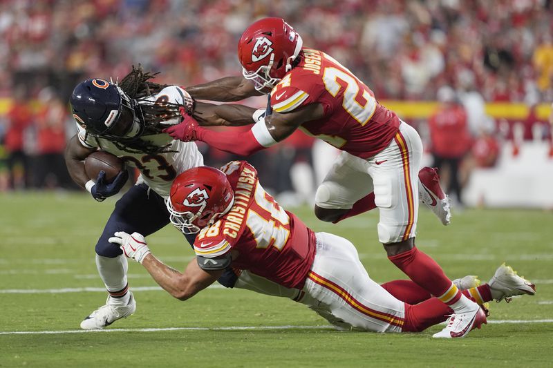 Chicago Bears running back Ian Wheeler, left, struggles for yardage against Kansas City Chiefs linebacker Cole Christiansen (48) and cornerback Kelvin Joseph, right, during the first half of an NFL preseason football game Thursday, Aug. 22, 2024, in Kansas City, Mo. (AP Photo/Charlie Riedel)