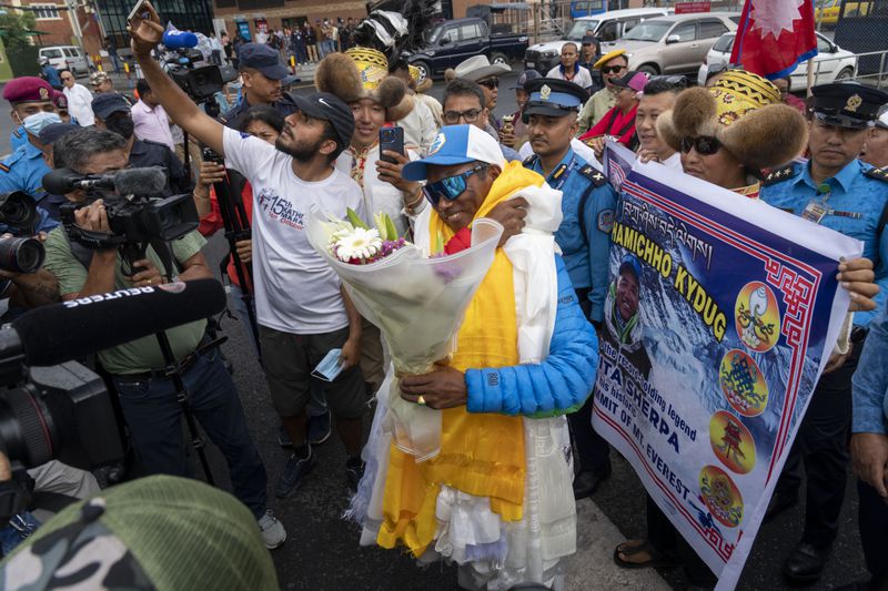 Renowned Sherpa mountain guide Kami Rita returning from Mount Everest after his record 30th successful ascent, is presented with shawls and flowers he arrives at the airport in Kathmandu, Nepal, Friday, May 24, 2024. (AP Photo/Niranjan Shrestha)