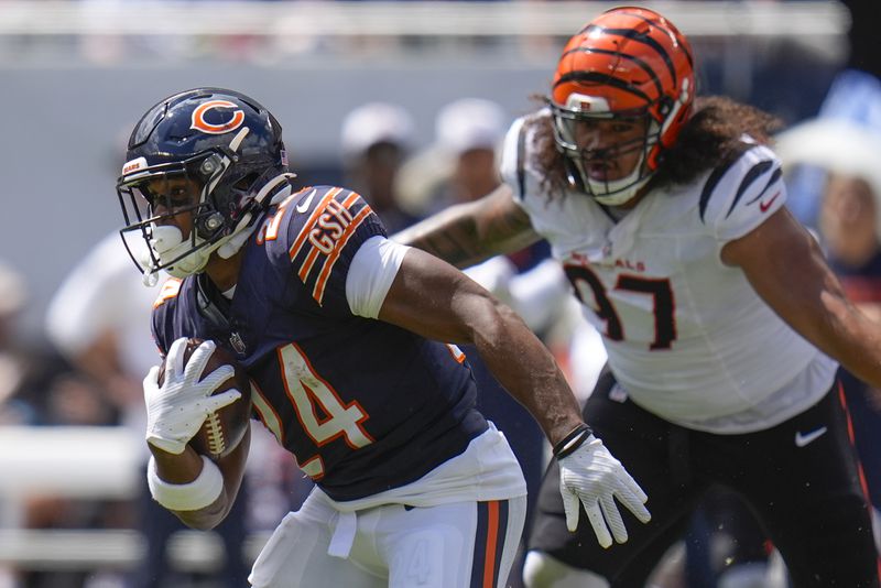 Chicago Bears running back Khalil Herbert (24) runs past Cincinnati Bengals defensive tackle Jay Tufele (97) during the first half of an NFL preseason football game, Saturday, Aug. 17, 2024, at Soldier Field in Chicago. (AP Photo/Erin Hooley)