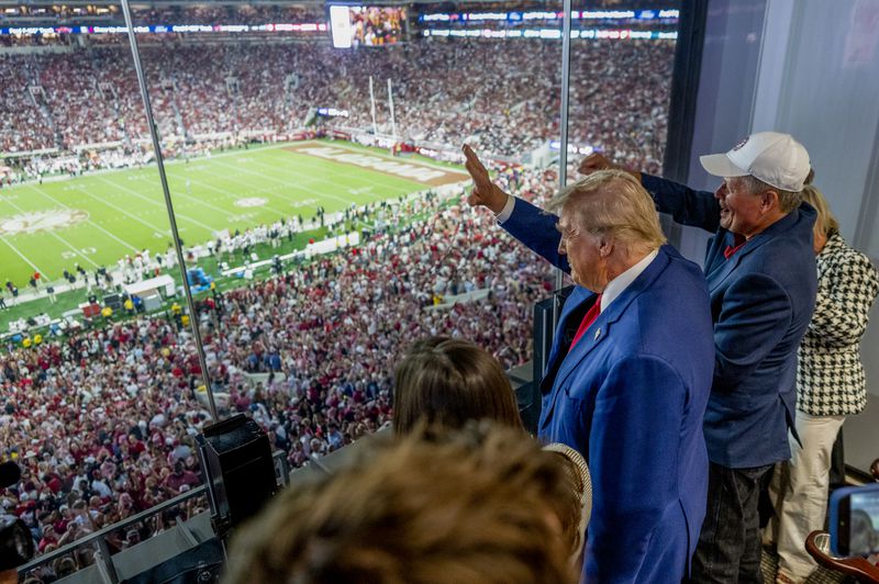 Former President Donald Trump, the Republican presidential nominee, waves during the Georgia vs. Alabama football game Saturday at Bryant-Denny Stadium, in Tuscaloosa, Ala. (Doug Mills/The New York Times)