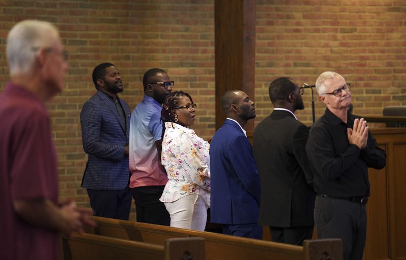 Members of the Haitian community, from left, Lindsay Aime, James Fleurijean, Rose-Thamar Joseph, Harold Herard, and Viles Dorsainvil, stand for worship with Carl Ruby, pastor at Central Christian Church, in Springfield, Ohio, on Sunday, Sept. 15, 2024. (AP Photo/Jessie Wardarski)