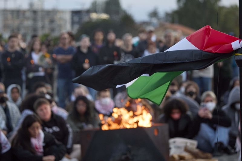 A Flag of Palestine waves in the breeze vigil on Alki Beach for the death of the 26-year old Aysenur Ezgi Eygi, killed recently in the occupied West Bank, Wednesday, Sept. 11, 2024, in Seattle. Eygi grew up in Seattle, attended Seattle Public Schools and graduated from the University of Washington. (AP Photo/John Froschauer)