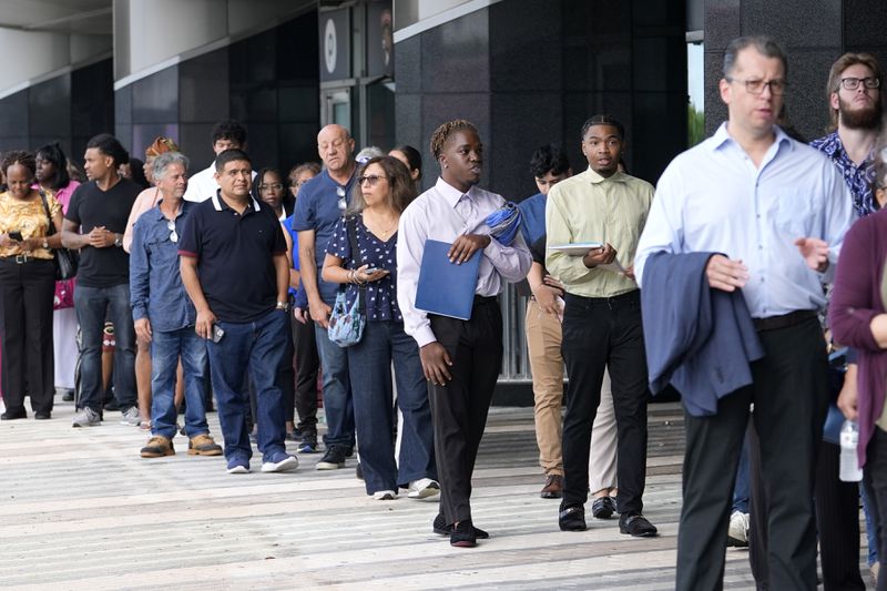 People wait in line to attend a job fair, Thursday, Aug. 29, 2024, in Sunrise, Fla. (AP Photo/Lynne Sladky)