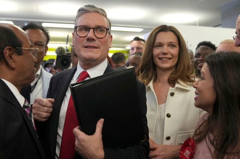 Labour Party leader Keir Starmer with his wife Victoria make their way through supporters as they arrive at the count for the Holborn and St Pancras Parliamentary constituency where the Starmer is standing for election, in London, Friday, July 5, 2024. Britain's Labour Party appears to be headed for a huge majority in the 2024 UK election, an exit poll suggested. The poll released moments after voting closed indicated that Labour leader Keir Starmer will be the country's next prime minister. (AP Photo/Kin Cheung)