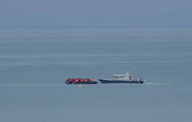 A boat thought to be with migrants is escorted by a vessel from the French Gendarmerie Nationale off the Wimereux beach, France, Wednesday, Sept. 4, 2024. A boat carrying migrants ripped apart in the English Channel as they attempted to reach Britain from northern France on Tuesday, plunging dozens into the treacherous waterway and leaving 12 dead, authorities said. (AP Photo/Nicolas Garriga)