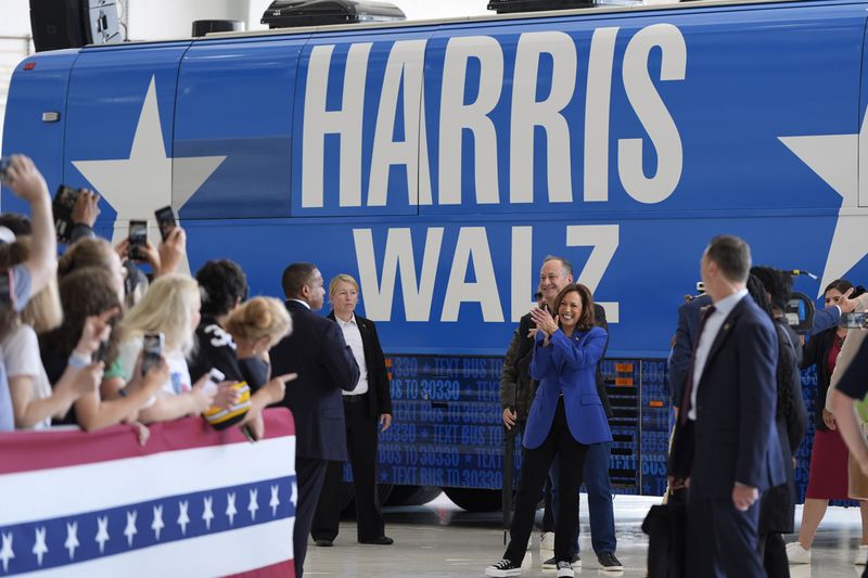 Democratic presidential nominee Vice President Kamala Harris claps alongside second gentleman Doug Emhoff as they greet supporters at Pittsburgh International Airport, Sunday, Aug. 18, 2024, in Pittsburgh. (AP Photo/Julia Nikhinson)