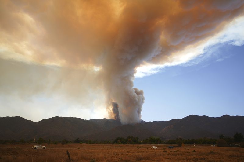 A plume of smoke created by the Airport Fire is seen on a mountain top Tuesday, Sept. 10, 2024, in Temescal Valley, Calif. (AP Photo/Eric Thayer)