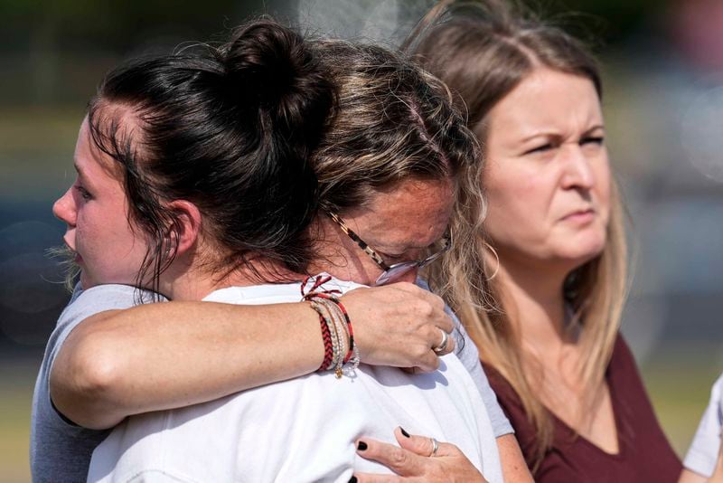 People embrace at a makeshift memorial after a shooting Wednesday at Apalachee High School, Thursday, Sept. 5, 2024, in Winder, Ga. (AP Photo/Mike Stewart)