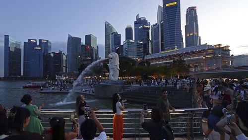 People take photos at Merlion Park in Singapore, Saturday, Sept. 7, 2024. (AP Photo/Suhaimi Abdullah)