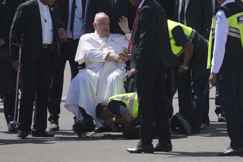 An airport staff kisses the Pope Francis' foot at Dili Presidente Nicolau Lobato International Airport in Dili, East Timor, Monday, Sept. 9, 2024. (AP Photo/Dita Alangkara)