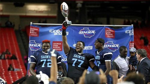 Cedar Grove's Netori Johnson (72), Justin Shaffer (77) and Jelani Woods (17) celebrate their win against Greater Atlanta Christian during the Class AAA state championship game Friday at the Georgia Dome.