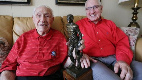 Georgia legends Charley Trippi, 96, with his Rose Bowl Hall of Fame trophy, and Vince Dooley, 85, share a laugh at the Trippi home on Thursday, Dec. 21, 2017, in Athens.