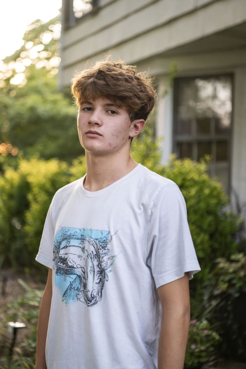 Chris Stanislawski, 14, poses for a portrait outside of his home in Garden City, N.Y., on Friday, Sept. 13, 2024. Chris didn't finish any books in his 8th grade English class, in part because their google classroom had detailed summaries of each chapter of every book. (AP Photo/Brittainy Newman)