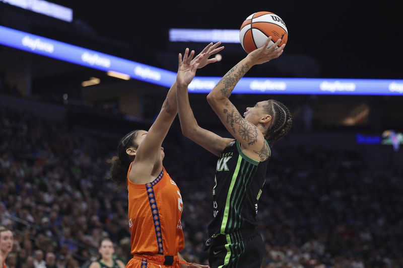 Minnesota Lynx guard Natisha Hiedeman, right, tries to make a basket against Connecticut Sun guard Veronica Burton, left, during the first half of Game 1 of a WNBA basketball semifinals series Sunday, Sept. 29, 2024, in Minneapolis. (AP Photo/Stacy Bengs)