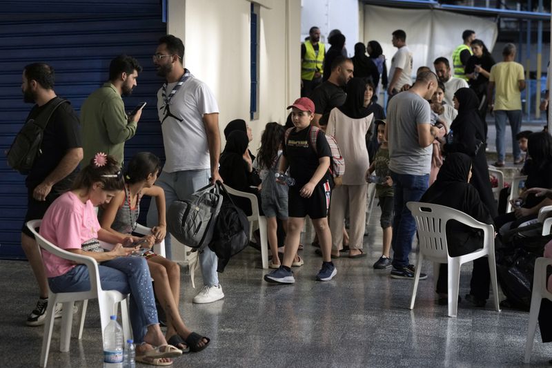 People fleeing the Israeli airstrikes in the south, arrive at a school turned into a shelter in Beirut, Monday, Sept. 23, 2024. (AP Photo/Bilal Hussein)