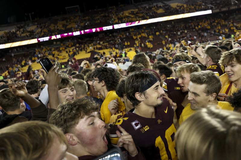 Minnesota quarterback Max Brosmer, center right, celebrates with fans after winning an NCAA college football game against Southern California Saturday, Oct. 5, 2024, in Minneapolis. (AP Photo/Ellen Schmidt)