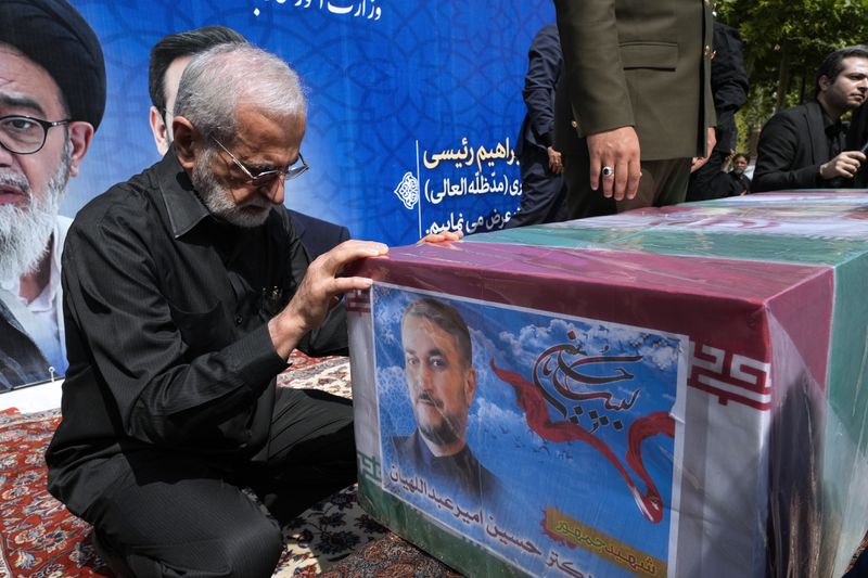 Former Iranian Foreign Minister Kamal Kharrazi pays respect to the flag-draped coffin of the late Foreign Minister Hossein Amirabdollahian, who was killed in a helicopter crash along with President Ebrahim Raisi on Sunday in a mountainous region of the country's northwest, during a funeral ceremony at the foreign ministry in Tehran, Iran, Thursday, May 23, 2024. The death of Raisi, Foreign Minister Hossein Amirabdollahian and six others in the crash on Sunday comes at a politically sensitive moment for Iran, both at home and abroad.(AP Photo/Vahid Salemi)
