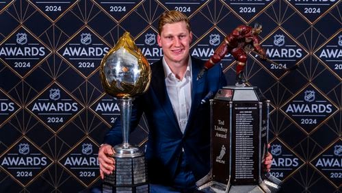 Colorado Avalanche forward Nathan MacKinnon stands with his trophies as the recipient of the Hart Memorial Trophy, left, and Ted Lindsay Award at hockey's NHL Awards, Thursday, June 27, 2024, in Las Vegas. (AP Photo/L.E. Baskow)