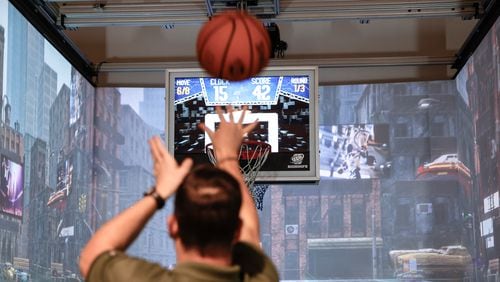 Big Hoops CEO Paul Brown shoots the basketball during a round of the game Tuesday, Dec. 19, 2023. Brown created the immersive basketball-themed experience in 2022 and plans to open locations in Atlanta in the coming years. (Natrice Miller/ Natrice.miller@ajc.com)