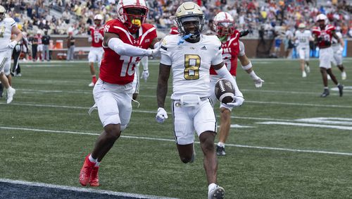 Georgia Tech wide receiver Malik Rutherford (8) runs in for a touchdown as Virginia Military Institute cornerback Asa Locks (16) defends after a catch during the first half of a NCAA college football game Saturday, Sept. 14, 2024, in Atlanta. The Jackets cruised 59-7. (AP Photo/John Bazemore)