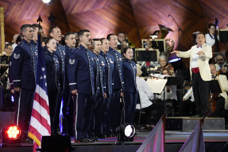 The Singing Sergeants sing the national anthem as Keith Lockhart, right, conducts during the Boston Pops Fireworks Spectacular at the Hatch Memorial Shell on the Esplanade in Boston, Thursday, July 4, 2024. (AP Photo/Michael Dwyer)
