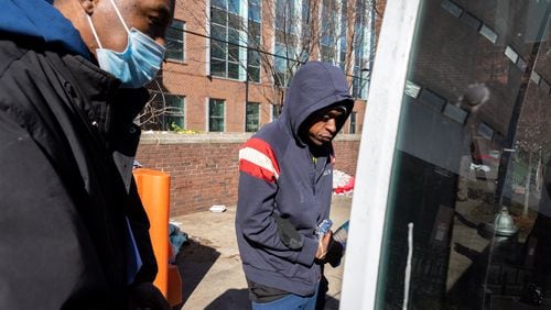 Siegfried Darcell White (left), with Concerned Dads and Not on My Watch Ministry, prepares to transport Uriah Burns (right) and other unhoused people from Gateway Center in Atlanta to a shelter on Tuesday, January 16, 2024. (Arvin Temkar / arvin.temkar@ajc.com)