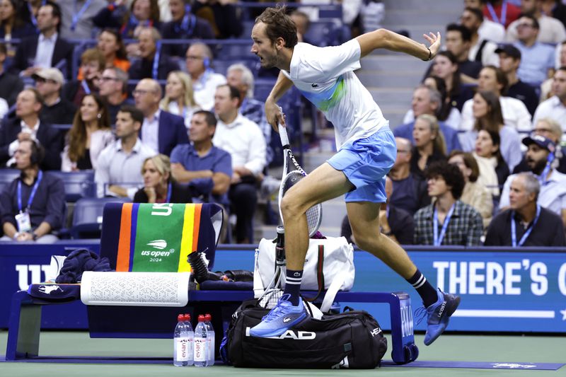 Daniil Medvedev, of Russia, leaps over the player's bench on a return against Jannik Sinner, of Italy, during the quarterfinals of the U.S. Open tennis championships, Wednesday, Sept. 4, 2024, in New York. (AP Photo/Adam Hunger)