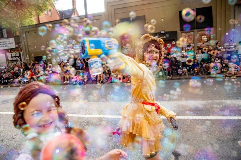 Hannah Post (aka Dorothy, left) and Charlotte Ward (the Cowardly Lion) make bubbles during last year's Dragon Con Parade.