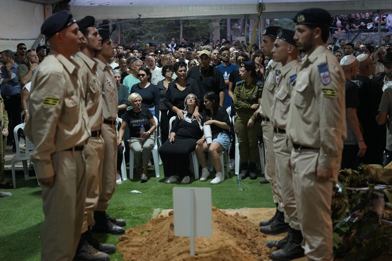 Relatives of Petty Officer 1st Class David Moshe Ben Shitrit, who was killed on a Hezbollah attack, mourn during his funeral at the Mount Herzl military cemetery in Jerusalem, Sunday, Aug. 25, 2024. (AP Photo/Ohad Zwigenberg)