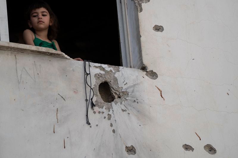 A girl looks out from a window of a building damaged by shrapnels after an Israeli forces raid in the West Bank Jenin refugee camp, Thursday, May 23, 2024. The Israeli military said Thursday it has completed a two-day operation in the occupied West Bank that the Palestinian Health Ministry says killed 12 Palestinians. Militant groups claimed at least eight of the dead as fighters, one from Hamas and seven from the Al-Aqsa Martyrs Brigade. (AP Photo/Leo Correa)