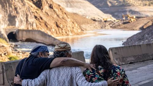 FILE - The Hillman family, from left, Leaf, Lisa, and Chaas, hug as construction crews removed the final cofferdam that was left of Iron Gate Dam allowing the Klamath River to run freely near Hornbrook, Calif., Aug. 28, 2024. (Carlos Avila Gonzalez/San Francisco Chronicle via AP, File)