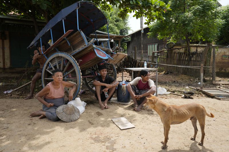 Local residents rest near a flooded road in Naypyitaw, Myanmar, Saturday, Sept. 14, 2024. (AP Photo/Aung Shine Oo)