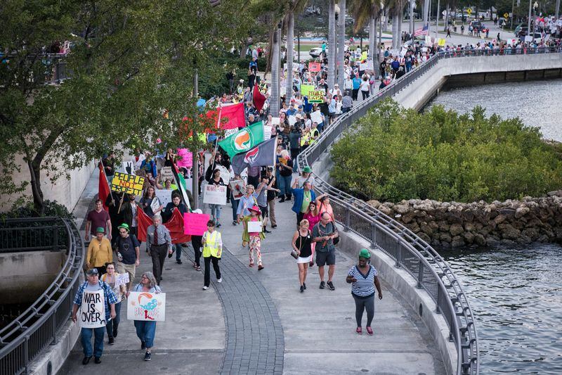 Protesters march down Flagler Drive in West Palm Beach as President Donald Trump and his wife Melania attend the 60th annual Red Cross Ball at the Mar-a-Lago on Saturday Feb. 4, 2017. (Michael Ares / The Palm Beach Post)